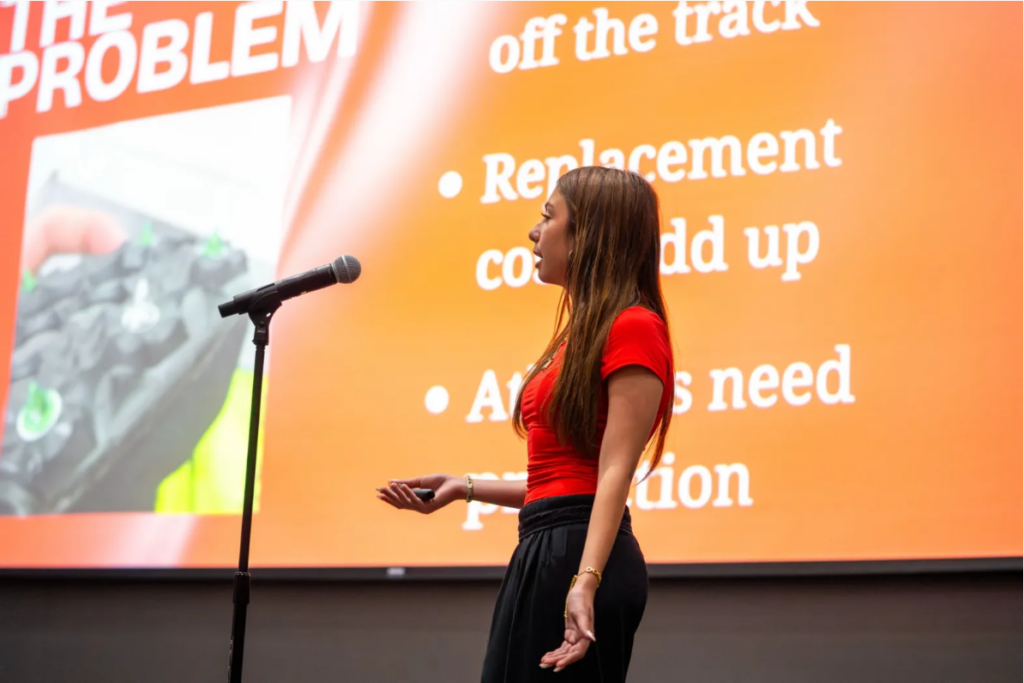 Student presents in front of a large screen
